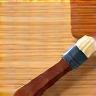Stylized icon representing a brush applying finish to wood